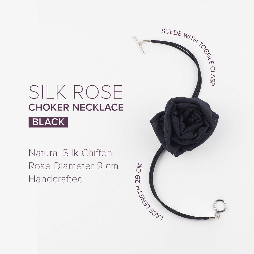 Black silk chiffon rose choker necklace with toggle clasp, photographed on a purple background with soft shadows.