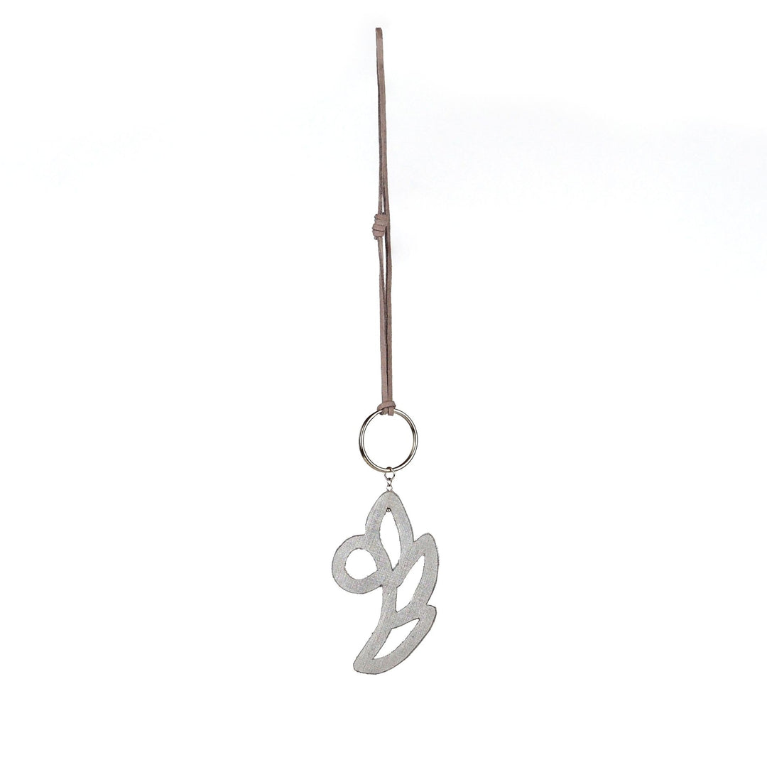 Back view of white and silver floral bag charm, finished with faux leather lining and suede strap