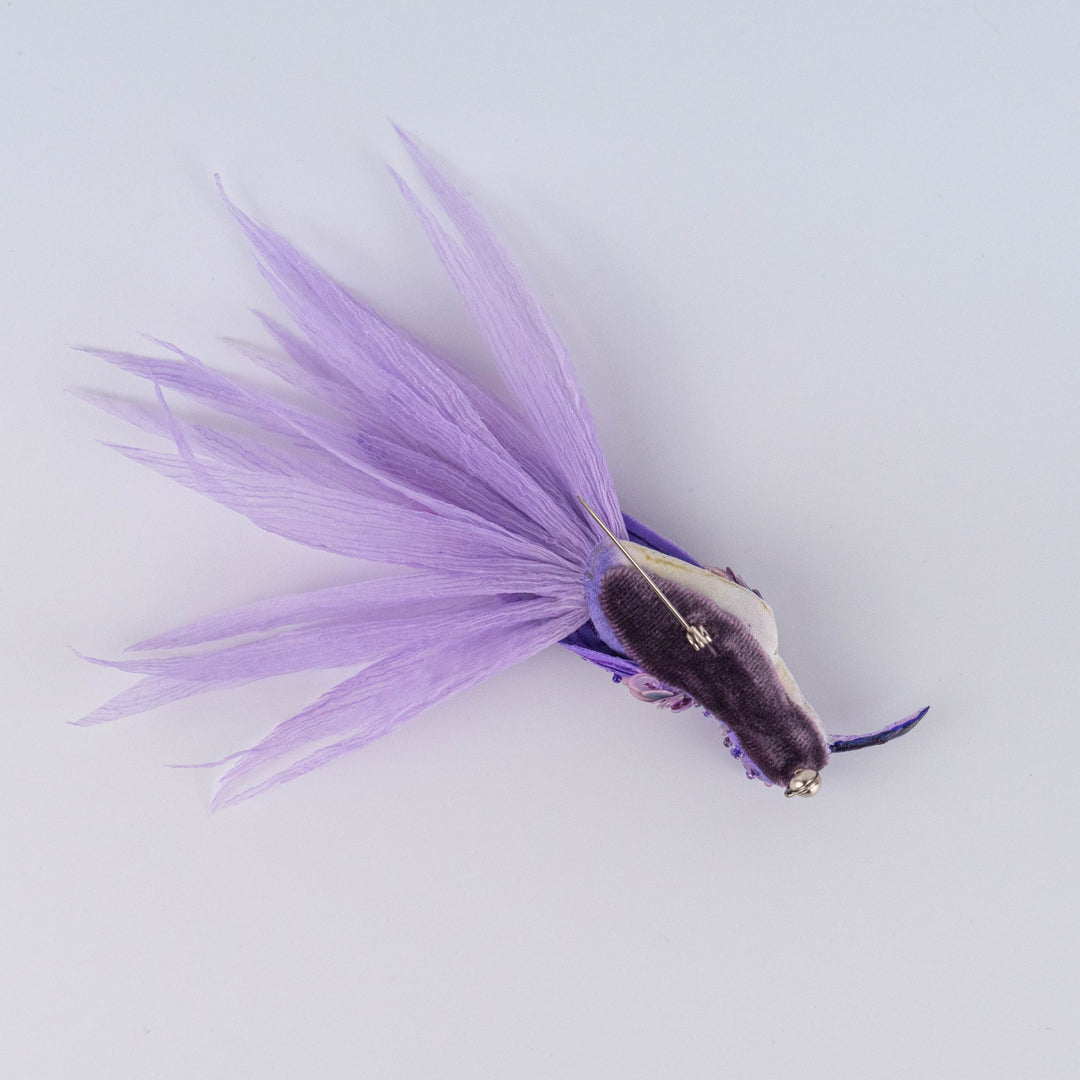 Close-up of feathered silk and chiffon tail on handmade purple hummingbird brooch, artistic textile jewellery, UK designer