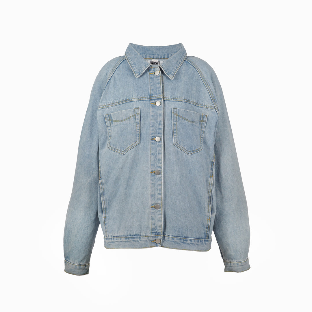 Front view of oversized light blue denim jacket with button closure, two chest pockets, and relaxed fit, displayed on a white background.