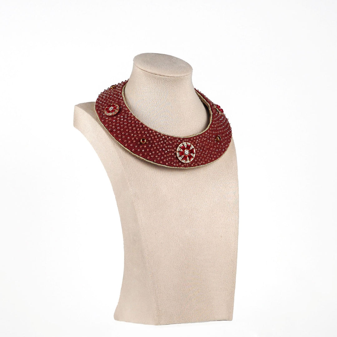 Angled view of handmade red collar necklace with bead setting and gold accents, shown on mannequin bust, statement boho accessory.