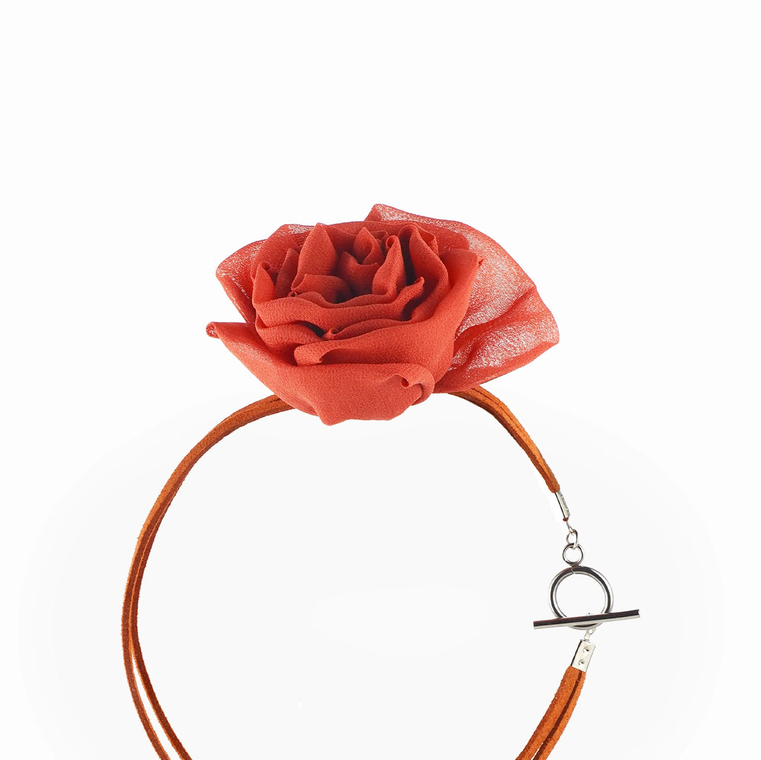 Close-up of handcrafted red silk rose on choker necklace with silver toggle clasp