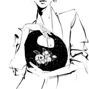 Black and white fashion illustration of a woman in a light blazer holding a rounded black tweed bag with hand-embroidered camellia flowers. Close-up sketch with expressive ink lines.