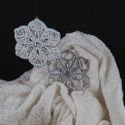 Hand-embroidered snowflake ornaments from the “Jewels of Winter” series by Ksenia Semirova. Unique fine-craft Christmas decorations made with pearl-setting embroidery using beads, cords, and crystals.