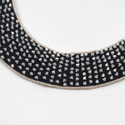 Close-up of pearl-tone cut beads with angular shapes, hand-set using a traditional pearl setting technique on a black collar necklace.