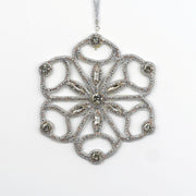 Close-up of the Jewels of Winter Six-Pointed Cut-Out Snowflake Ornament by Ksenia Semirova. Hand-embroidered with the pearl-setting technique using silver fire-polished glass beads and crystals, finished with a white leather back and silver hanging cord