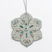 Close-up of the Jewels of Winter Six-Pointed Snowflake Ornament by Ksenia Semirova. Detailed bead and crystal work in white, silver, and turquoise tones, created with the pearl-setting technique and finished with a white leather back.