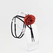 Handmade silk rose choker necklace with black long laces, displayed on a clear stand against a white background. Part of the Shadow & Bloom collection by BY ROVA