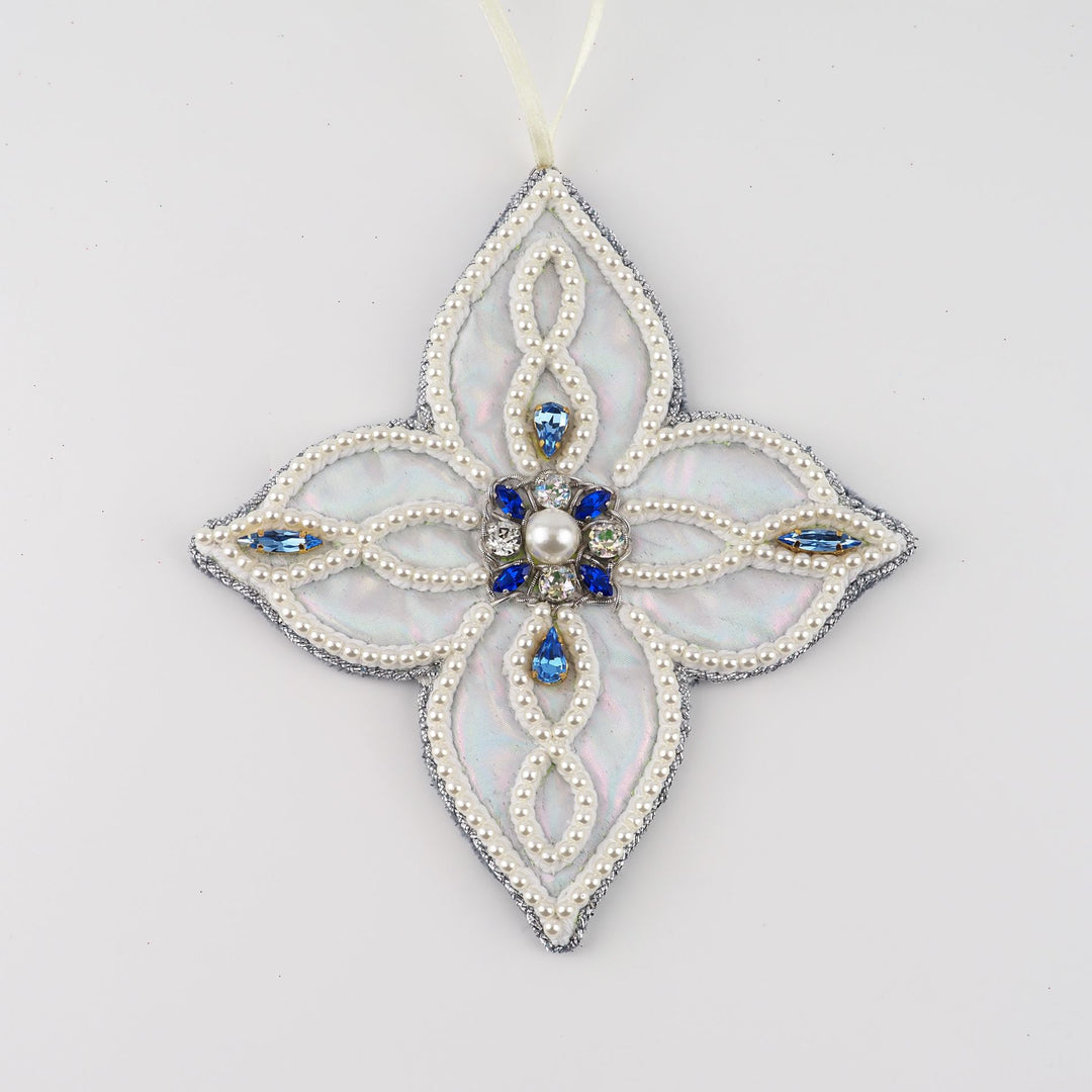 Hand-embroidered four-pointed snowflake ornament from the Jewels of Winter series by Ksenia Semirova. Made with the pearl-setting technique on iridescent faux leather, decorated with imitation pearls and blue vintage crystals.