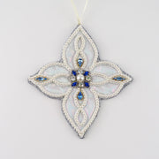 Hand-embroidered four-pointed snowflake ornament from the Jewels of Winter series by Ksenia Semirova. Made with the pearl-setting technique on iridescent faux leather, decorated with imitation pearls and blue vintage crystals.