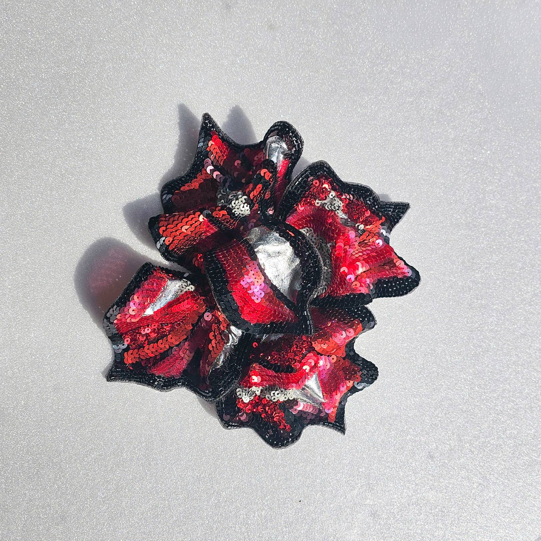 Front view of red and black hand-embroidered floral brooch by Ksenia Semirova, featuring sequins, beads, and silver details on silk organza