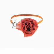 Red silk rose choker necklace laid in a circle showing toggle clasp and suede cord